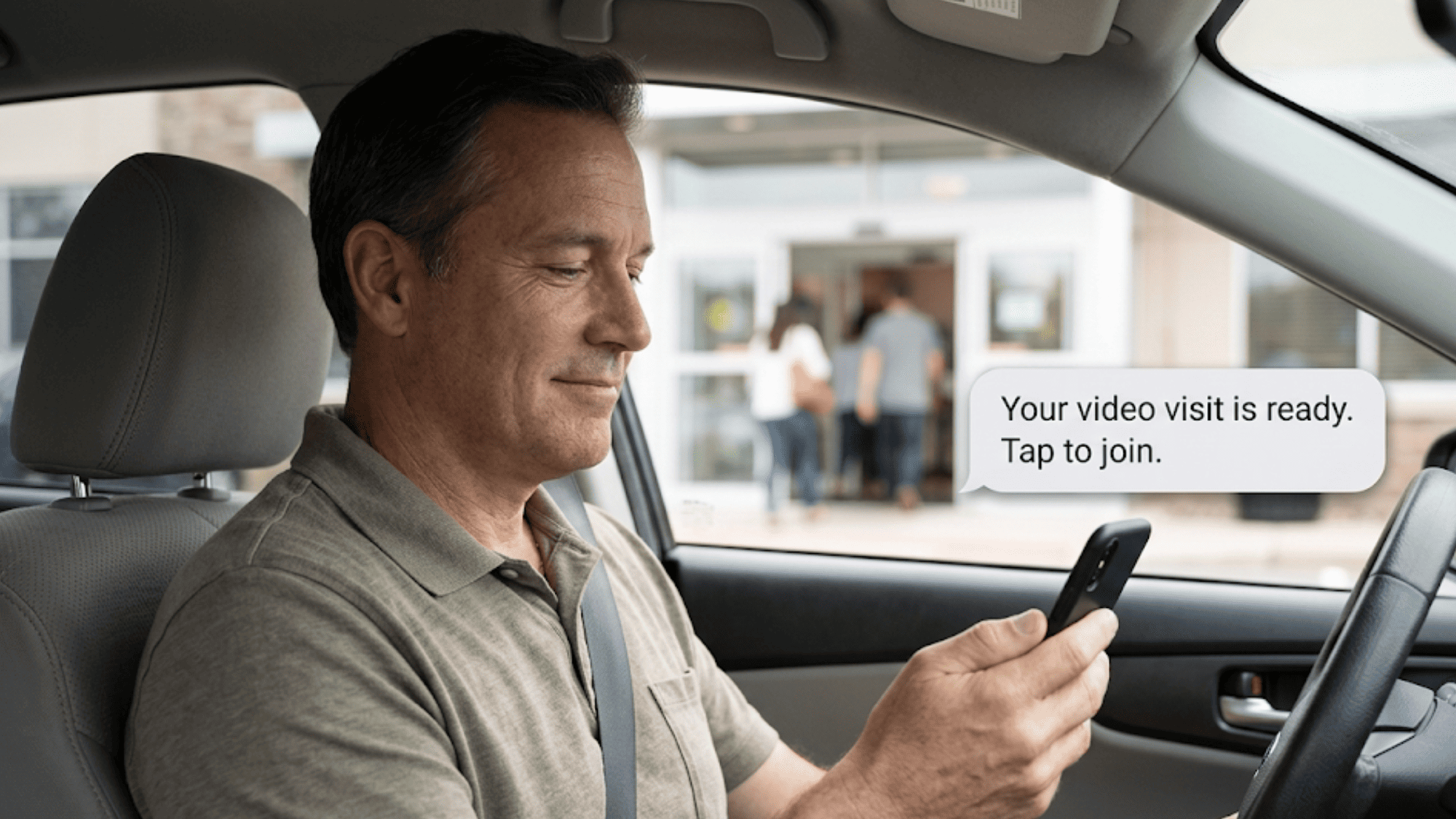 Man in a parked car looking at his phone with a floating text message launching his telemedicine video visit