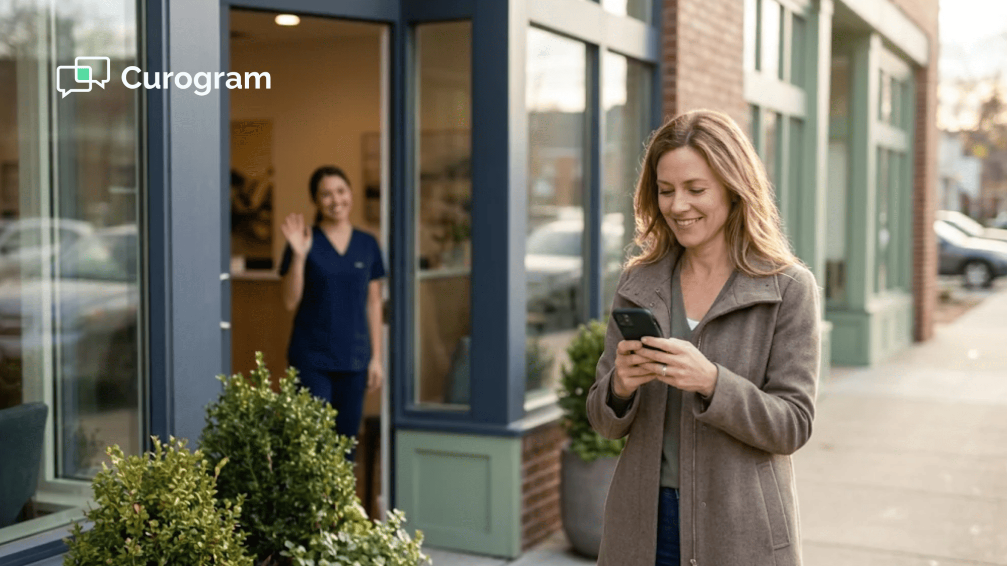 A smiling patient leaves a primary care clinic and checks her phone as the front desk waves goodbye