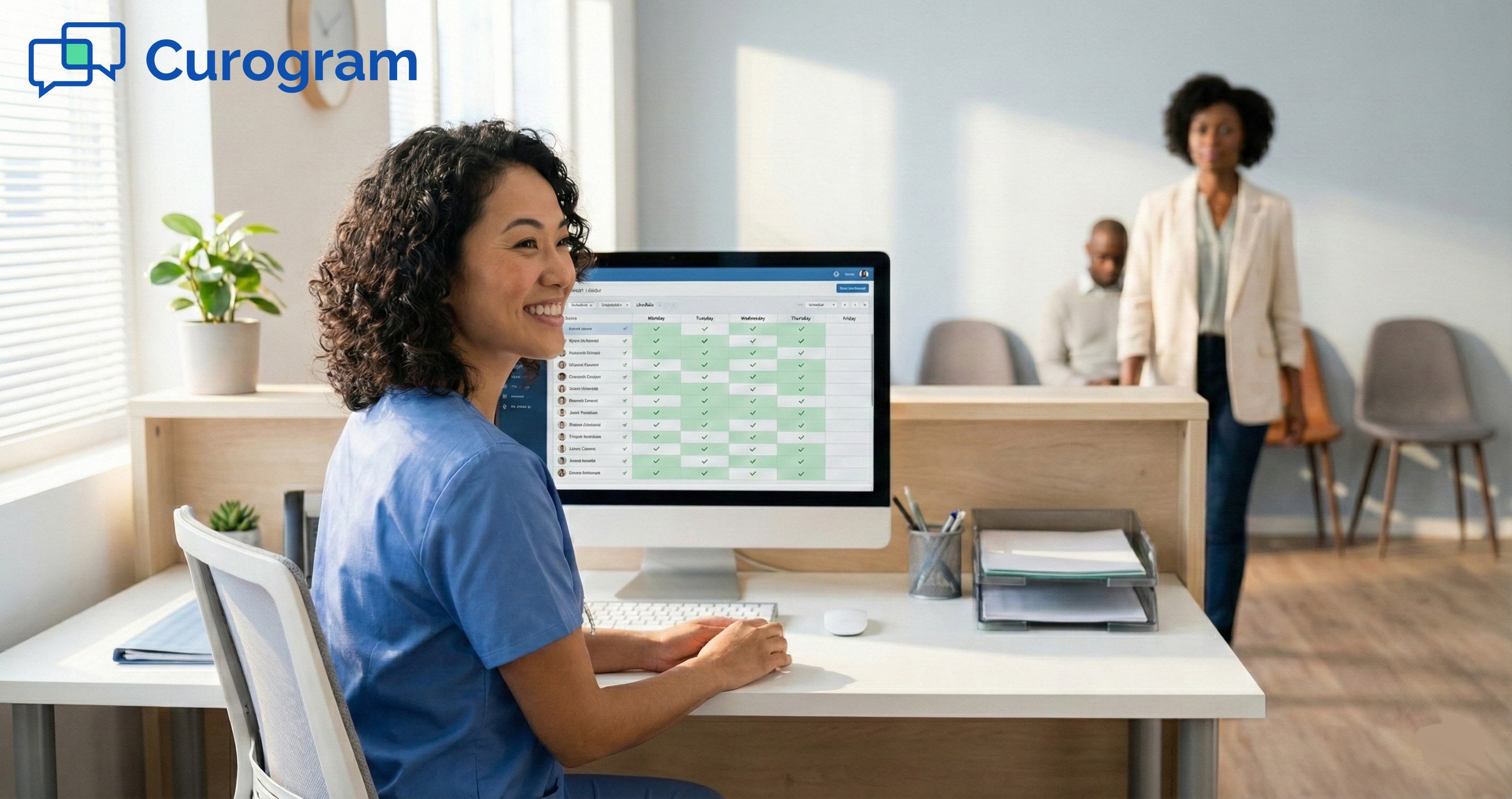 An Asian medical receptionist smiles at a clinic front desk while viewing a patient schedule