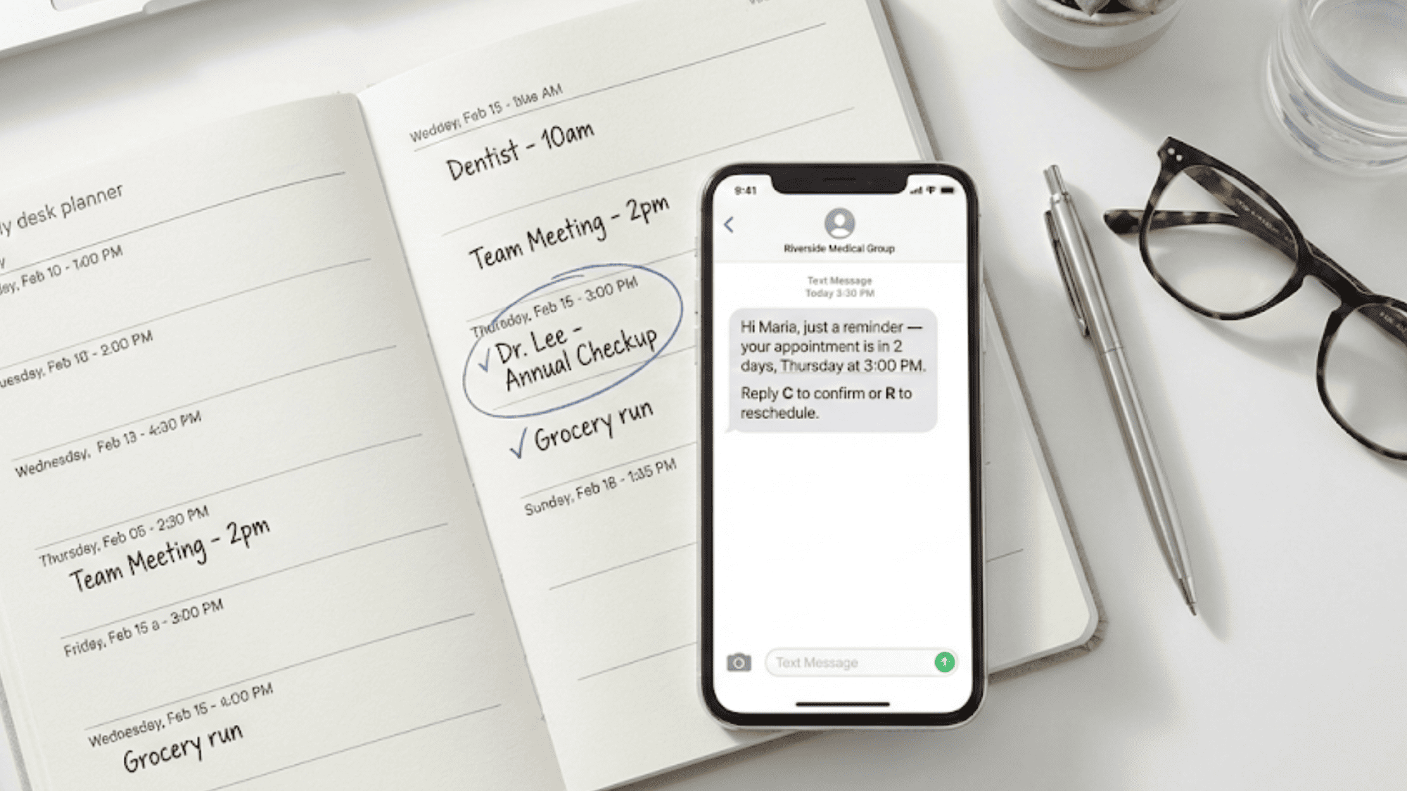 Flat lay of desk calendar and phone displaying appointment reminder before a scheduled visit