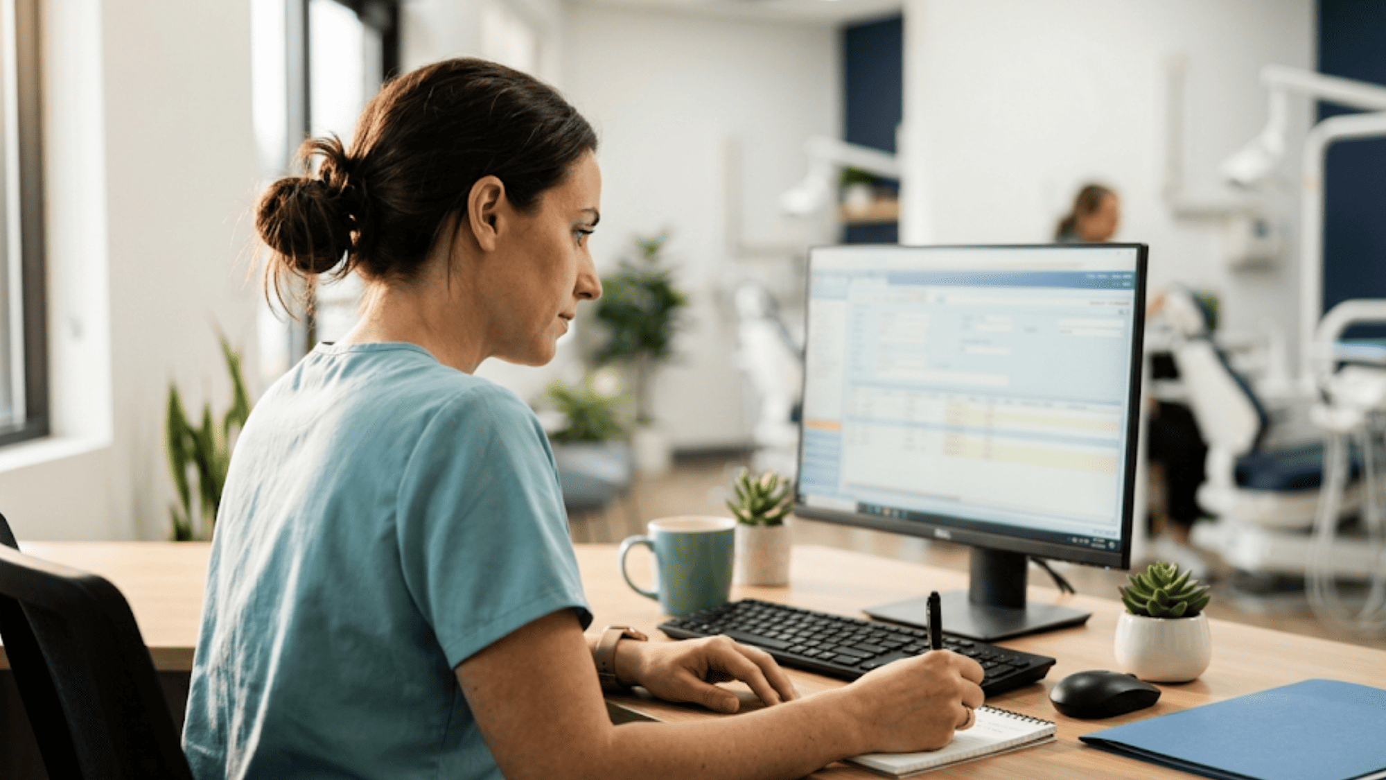 Calm treatment coordinator preparing case notes while using a Dolphin intake automation dashboard on her monito