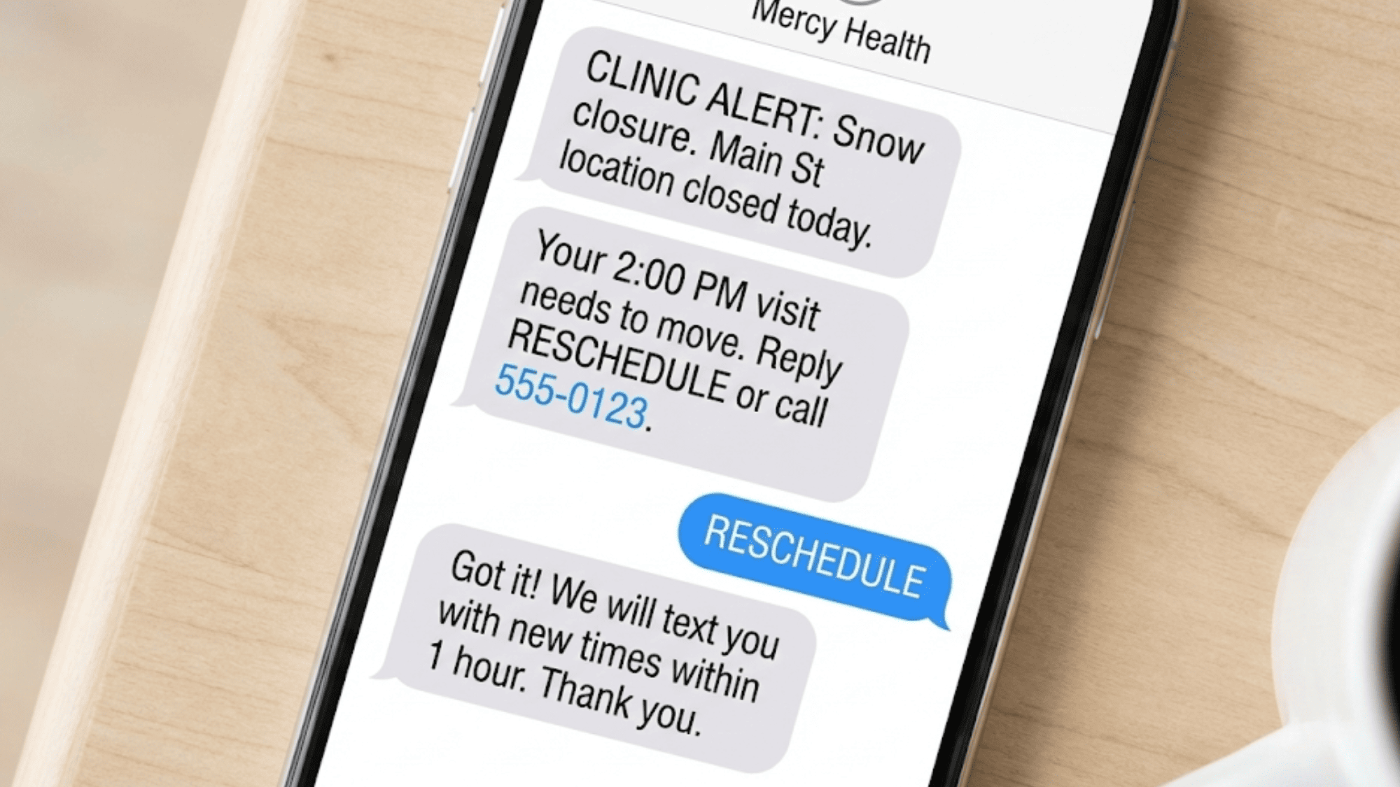 Mobile phone displaying HIPAA-compliant healthcare text messages notifying patient of appointment changes