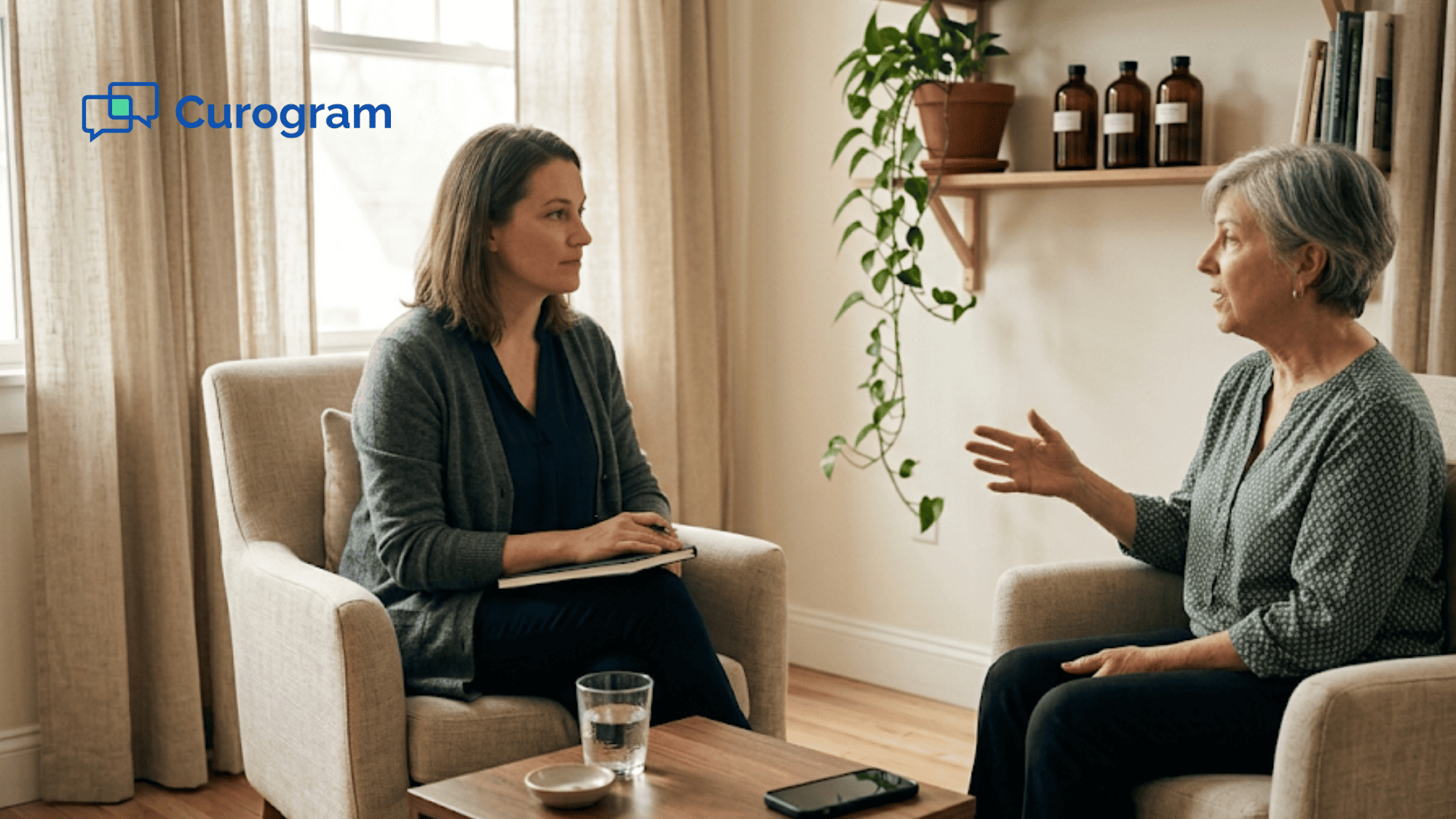 Direct primary care physician and patient talking in a warm consult room with a phone face down nearby