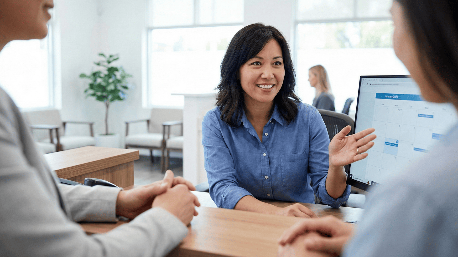 Patient speaking with clinic staff about appointment scheduling at front desk
