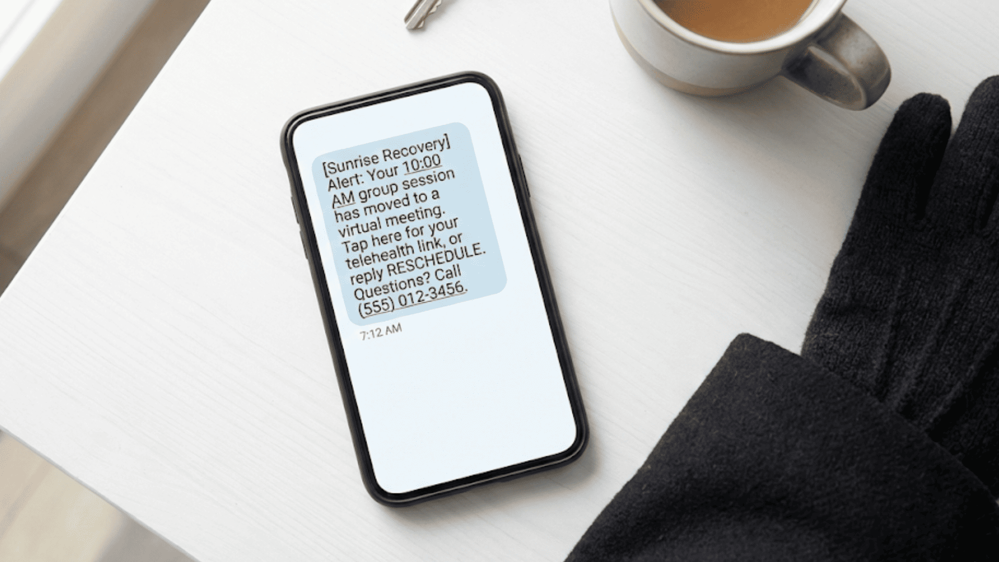 Smartphone displaying an Opus EHR broadcast alert SMS about a rescheduled group therapy session with a telehealth link