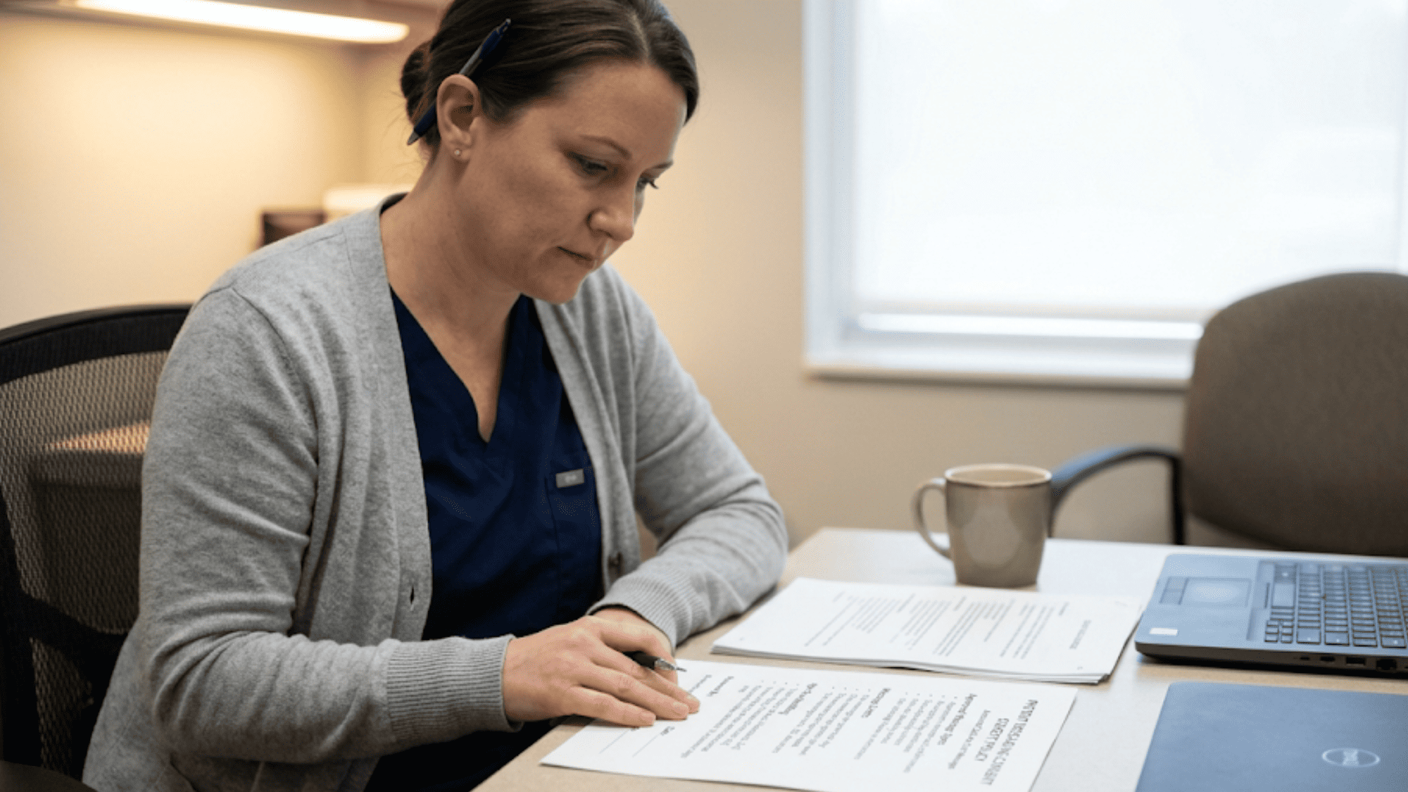 Medical office manager reviewing a printed patient messaging consent policy for TCPA compliance