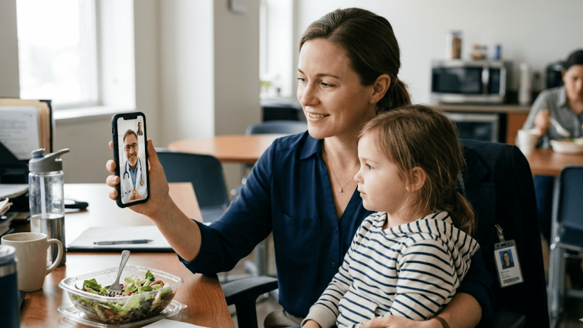 Working mother holding her child during a pediatric video visit from her office on lunch break