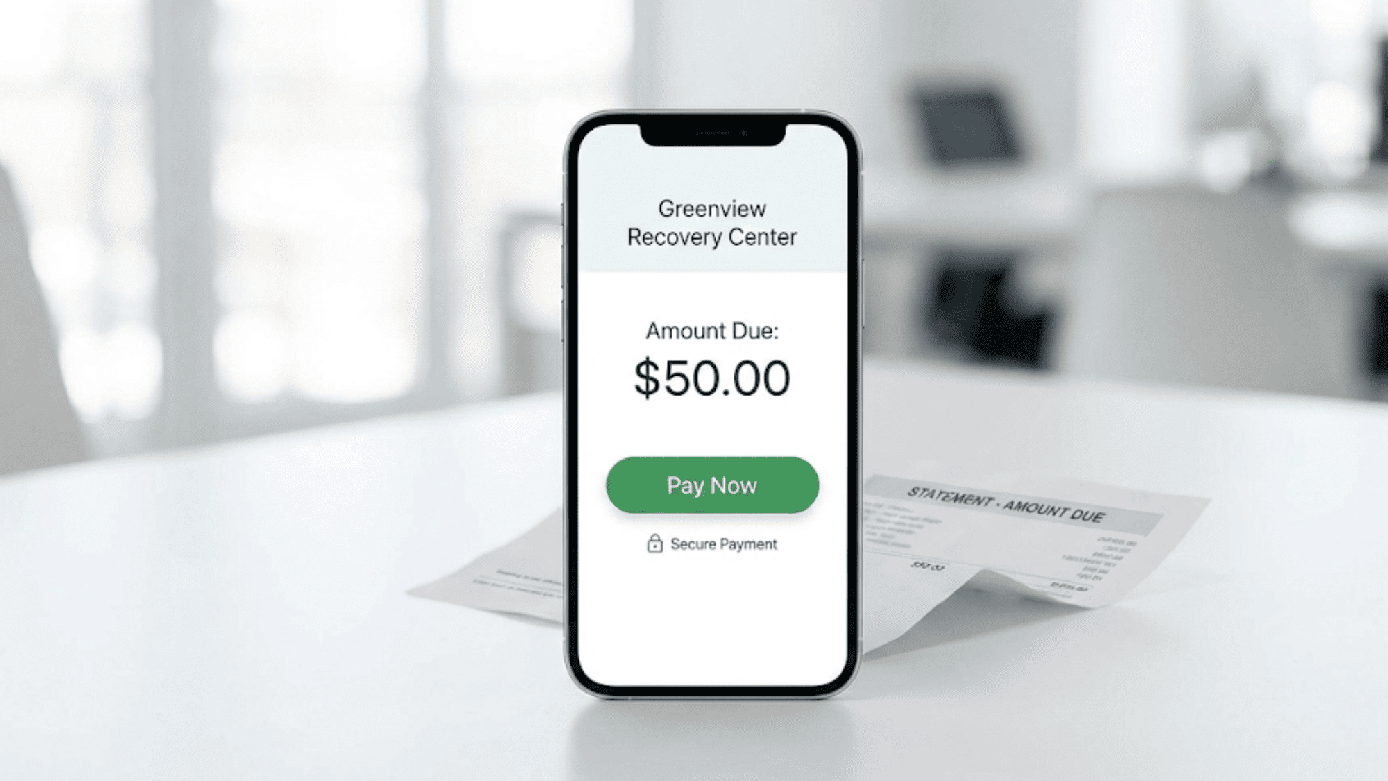 Close-up of a mobile payment screen with pay now button next to a paper statement on a desk