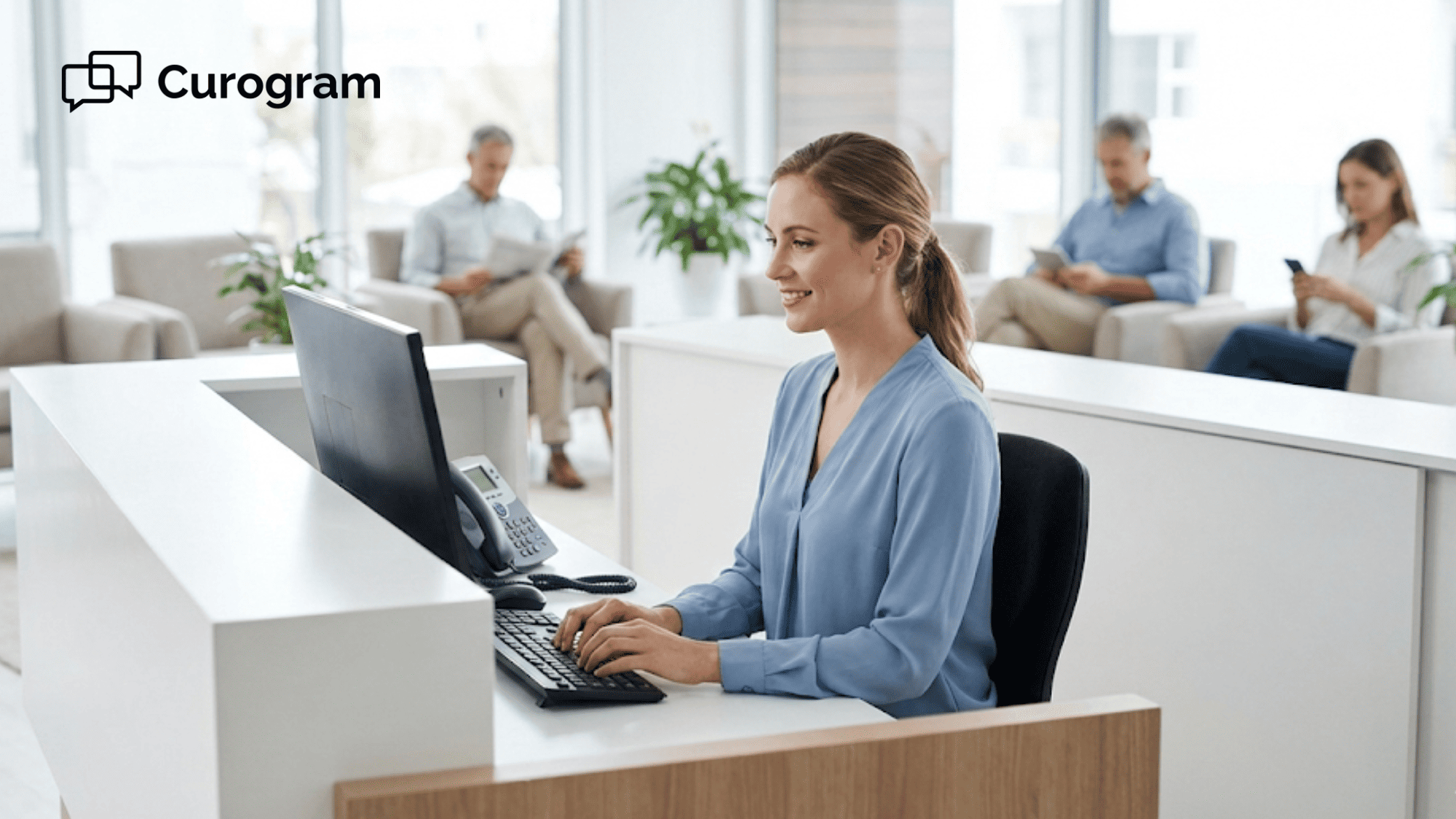 Medical receptionist working at a clean desk with an untouched phone nearby