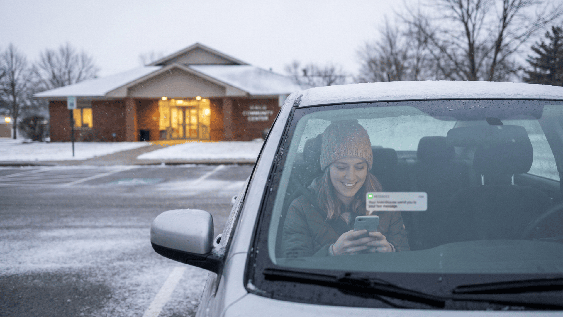 Young woman checking a text cancellation alert on her phone in a parked car