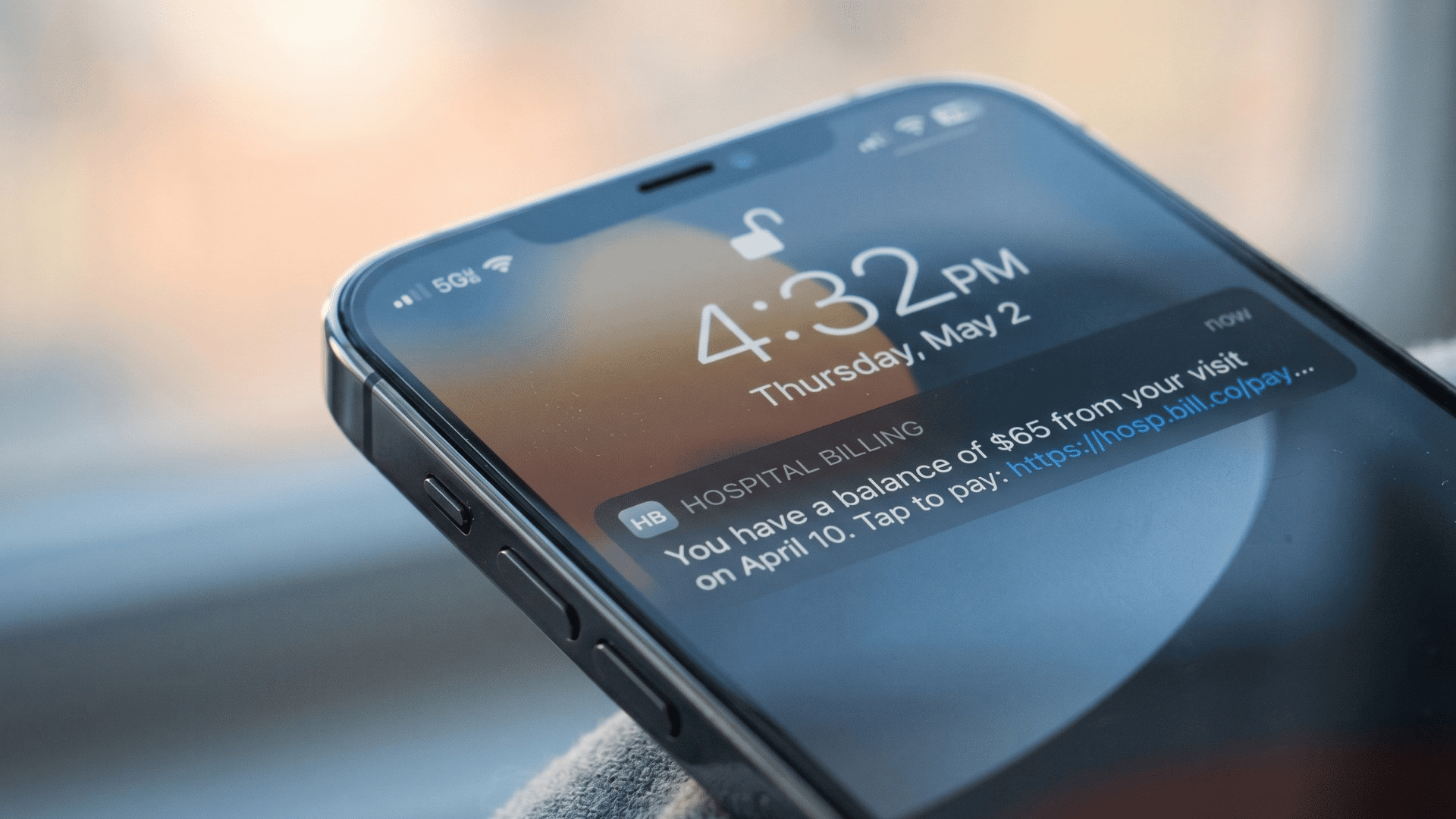 Smartphone lock screen showing a Meditab IMS text-to-pay payment link notification in soft daylight.