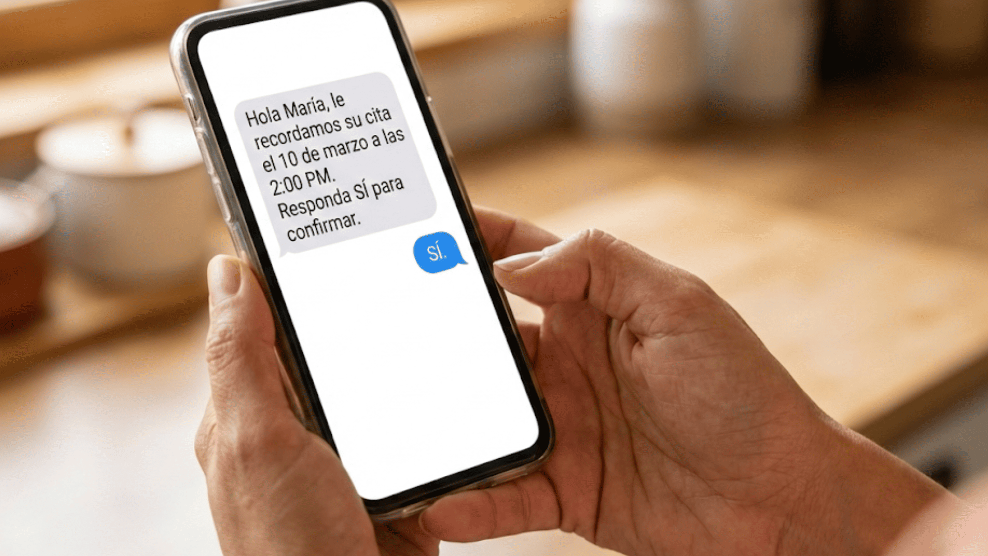 Patient holding smartphone showing a Spanish appointment reminder text message
