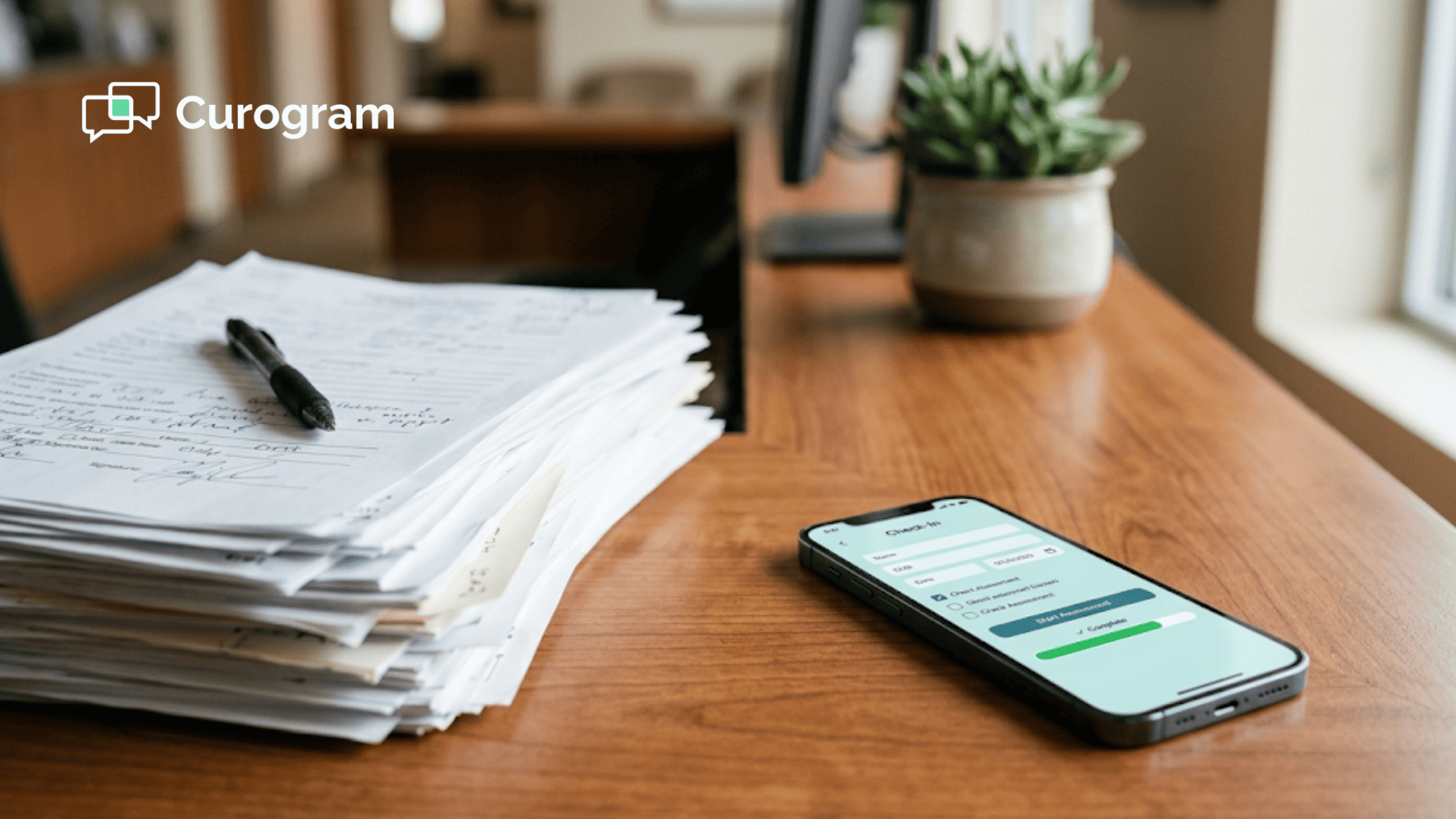 Paper oncology intake forms stacked beside a smartphone showing a digital alternative on a clinic desk