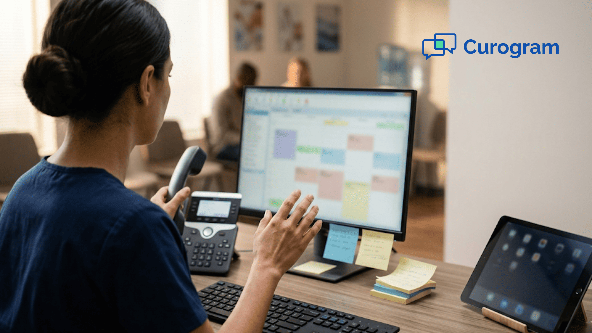 Front desk receptionist juggling a phone, sticky notes, and separate screens at a small clinic