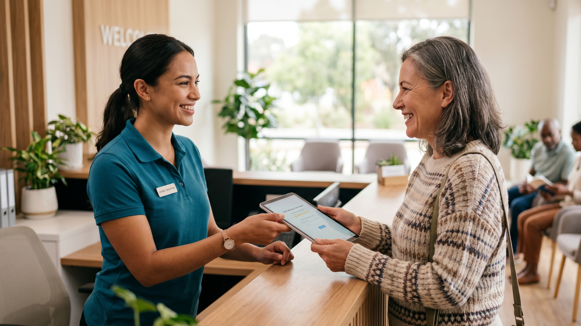 Front-desk staff handing tablet to patient for post-visit Google review at medical practice