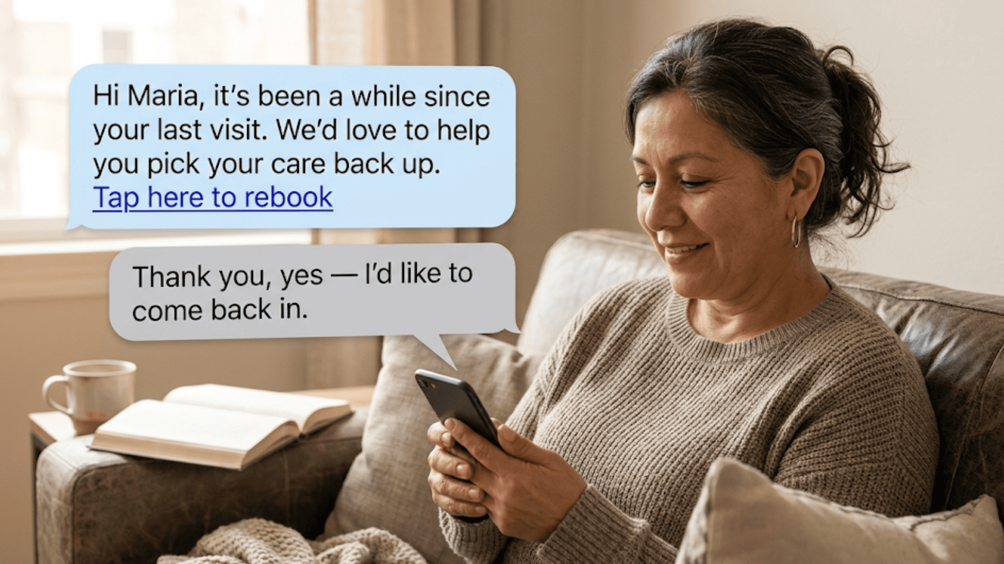 Client smiling at phone reading a clinic recall text with a rebook link