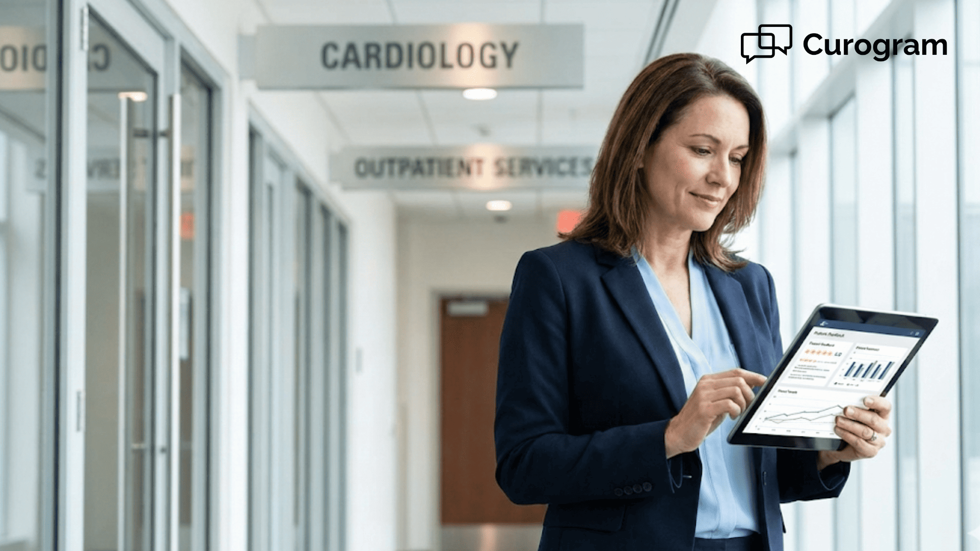 Healthcare executive reviewing patient feedback data on tablet in hospital hallway