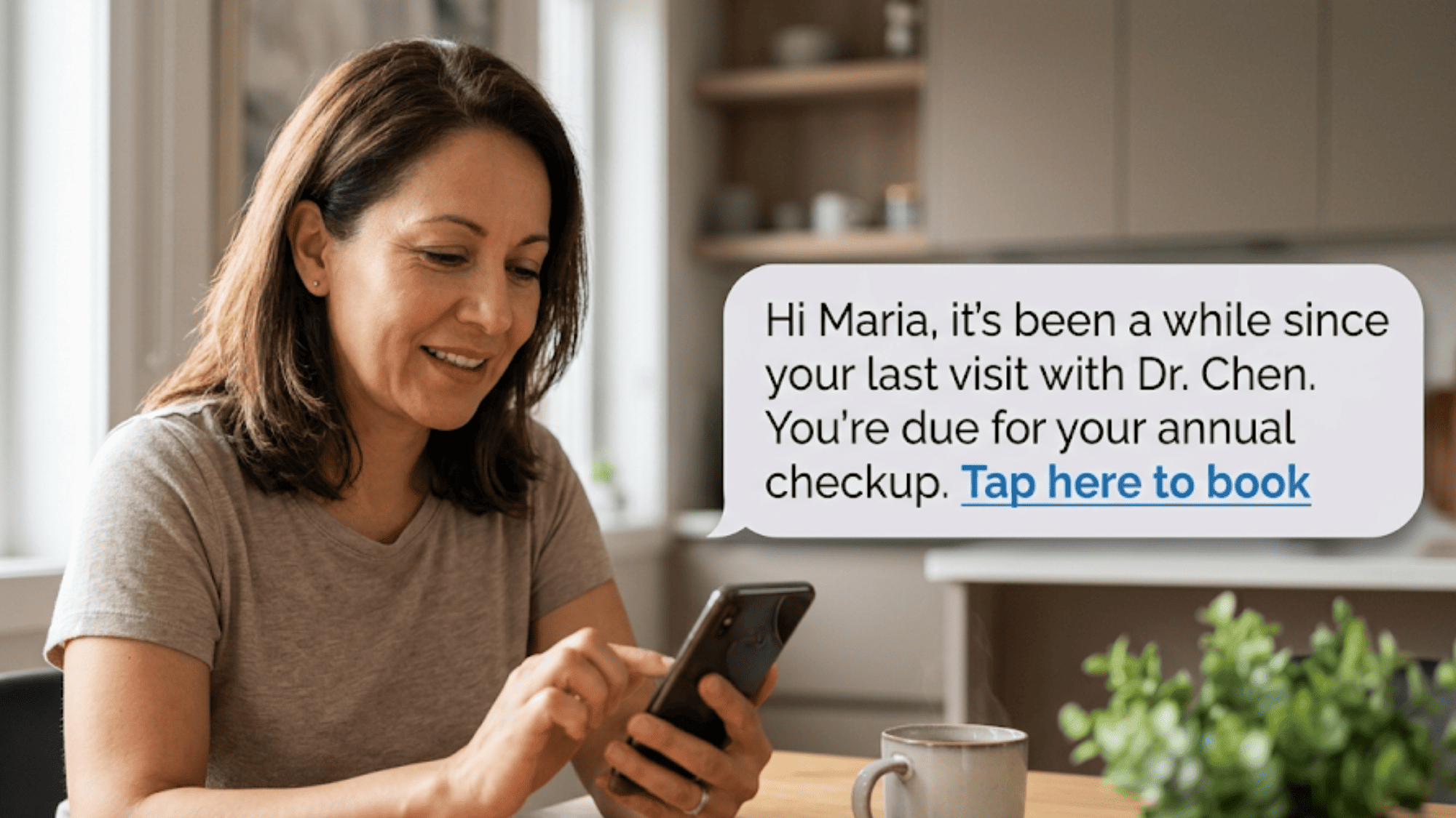 Woman at kitchen table reading SMS patient recall message from her primary care clinic