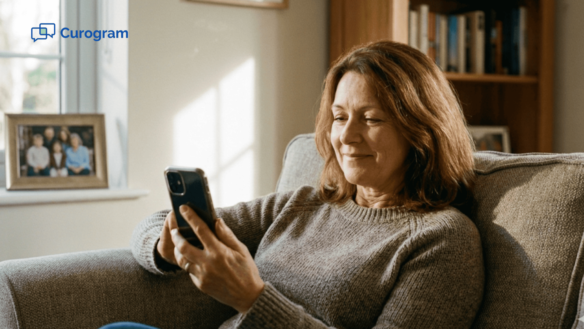 Woman sitting on a couch looking at her smartphone with relief after completing a medical payment