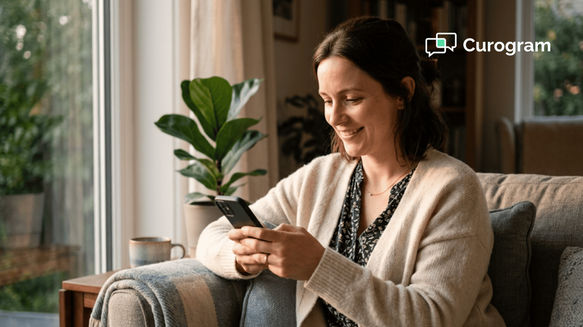 Hopeful person holding a phone at home and reading an SMS