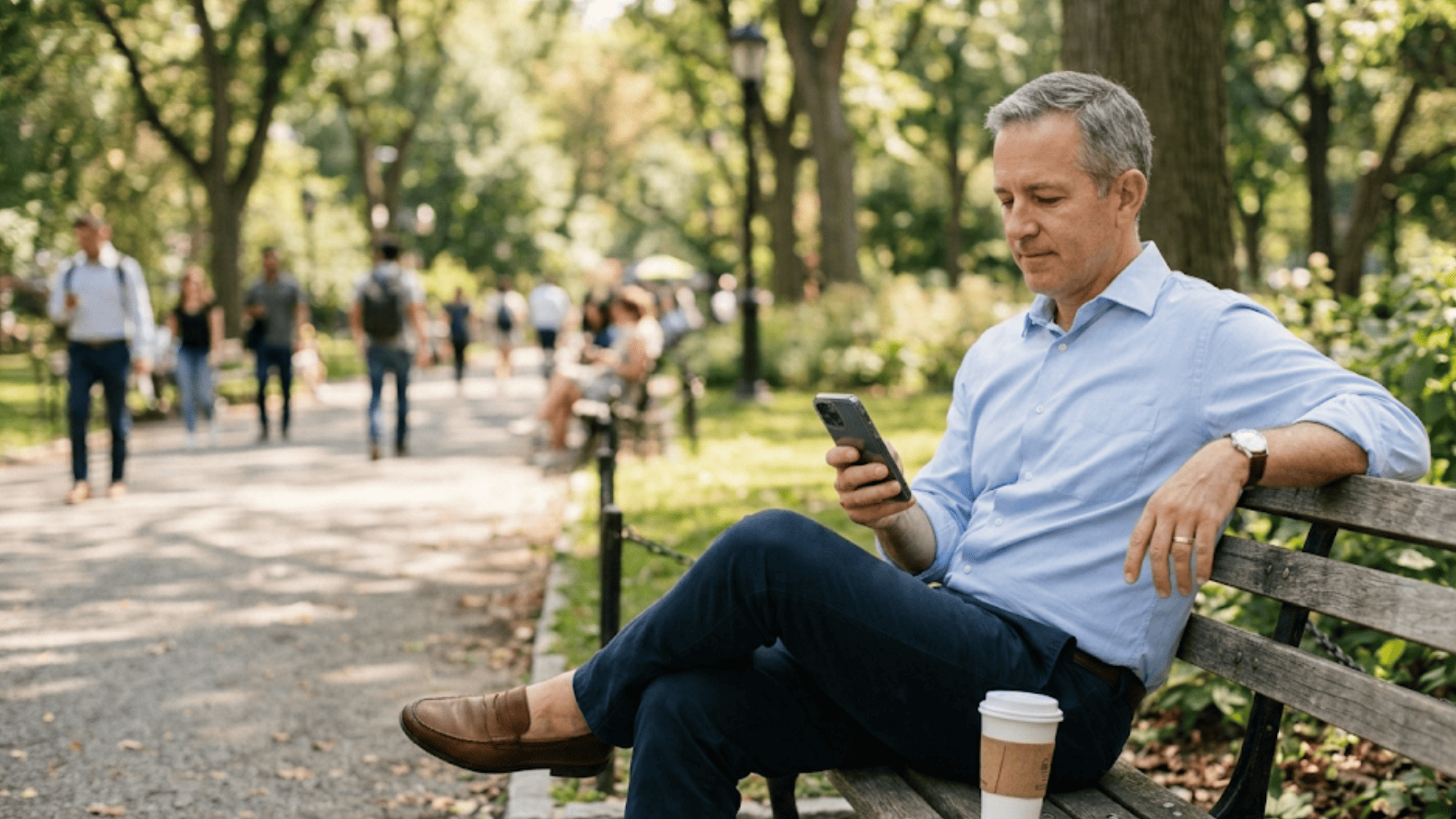 Man on a park bench casually confirming a medical appointment on his phone during a lunch break