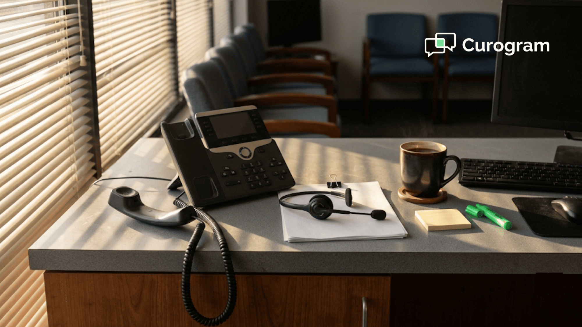 Empty medical front desk at sunrise with a desk phone off the hook beside a headset and call sheet