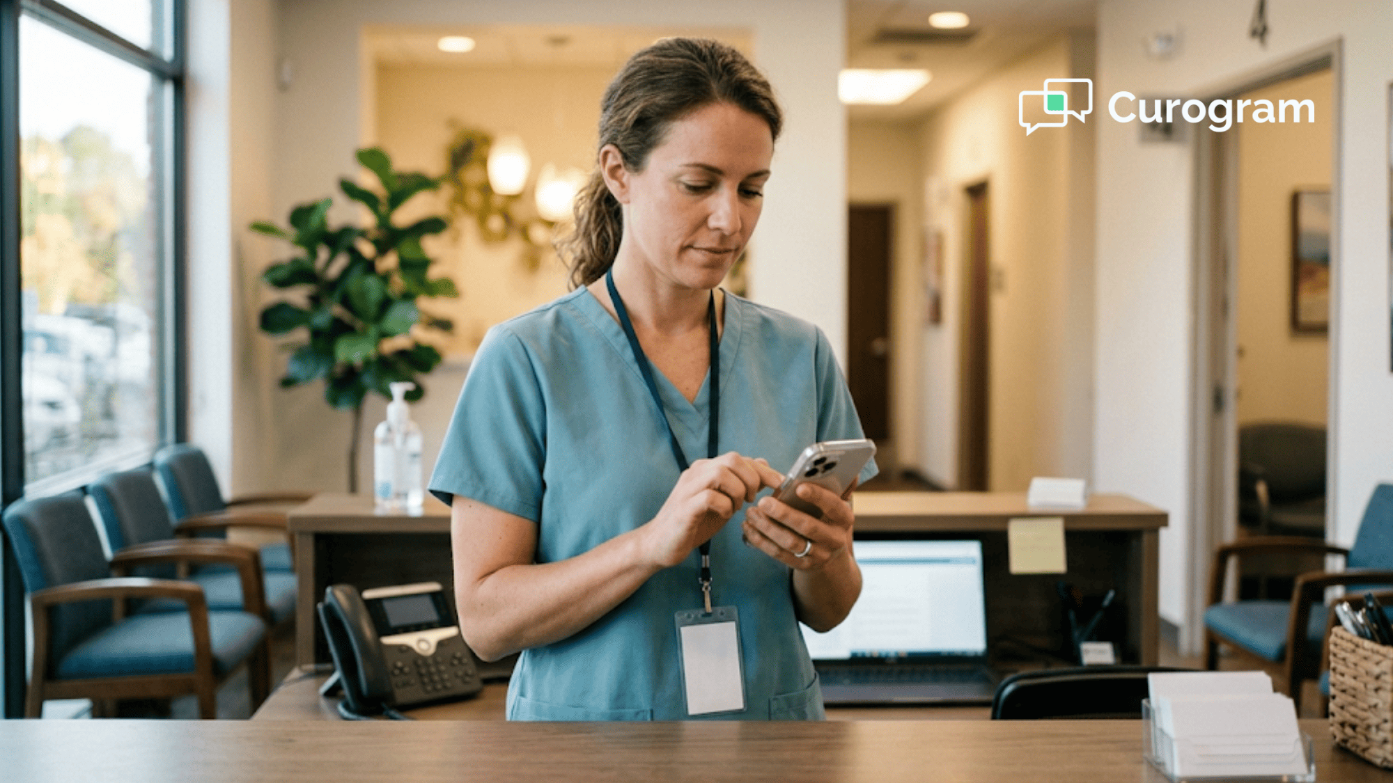 Clinic front desk coordinator in scrubs replies to a patient text message at the reception counter
