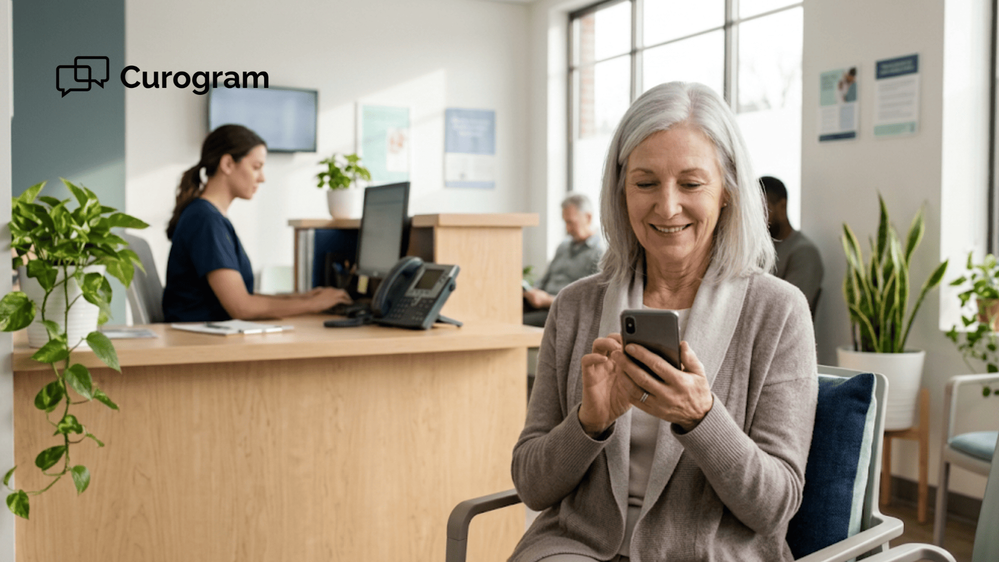 Older patient in a clinic waiting room replies to an appointment text on her phone while front desk staff work calmly