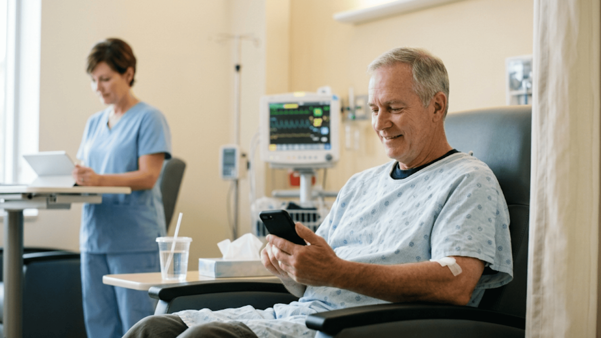 OBL patient checking phone post-procedure as nurse reviews tablet in background