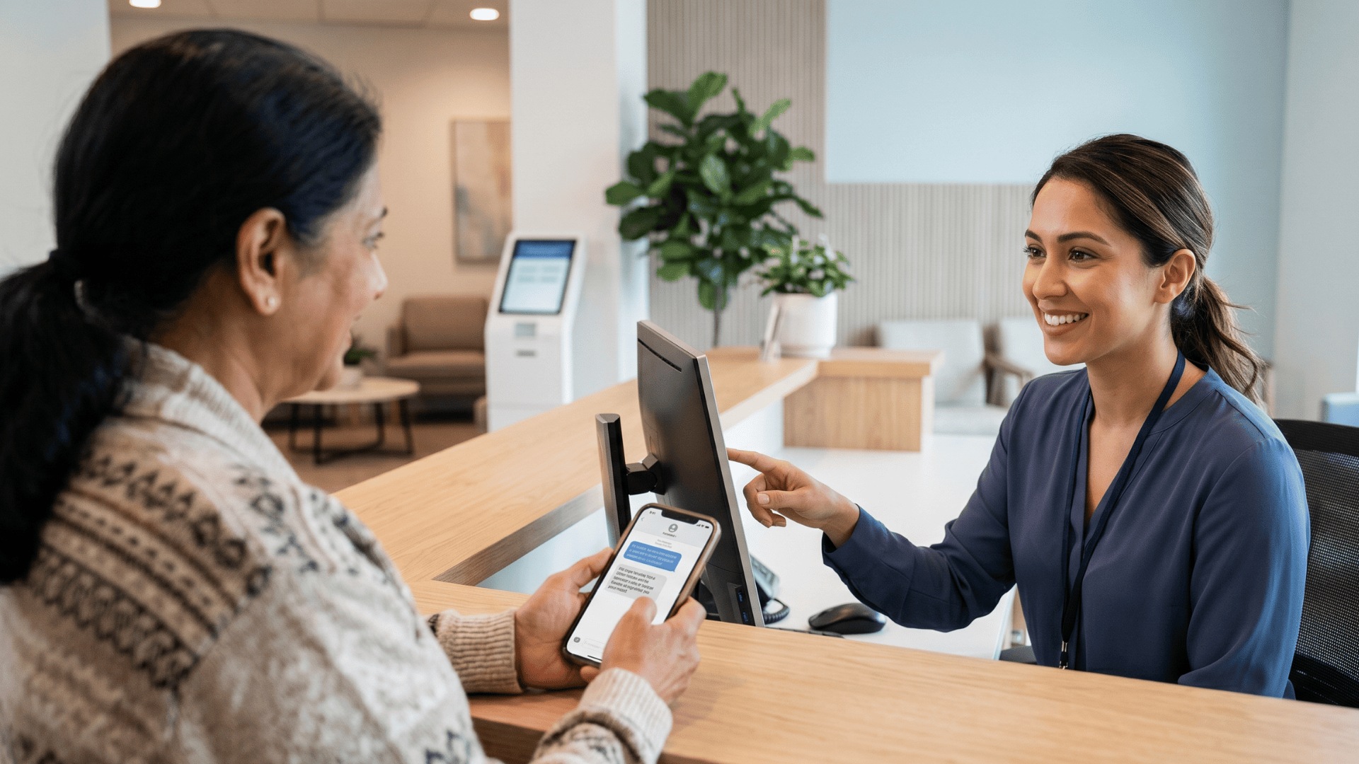 Medical receptionist assisting patient at check-in after SMS appointment recall reminder