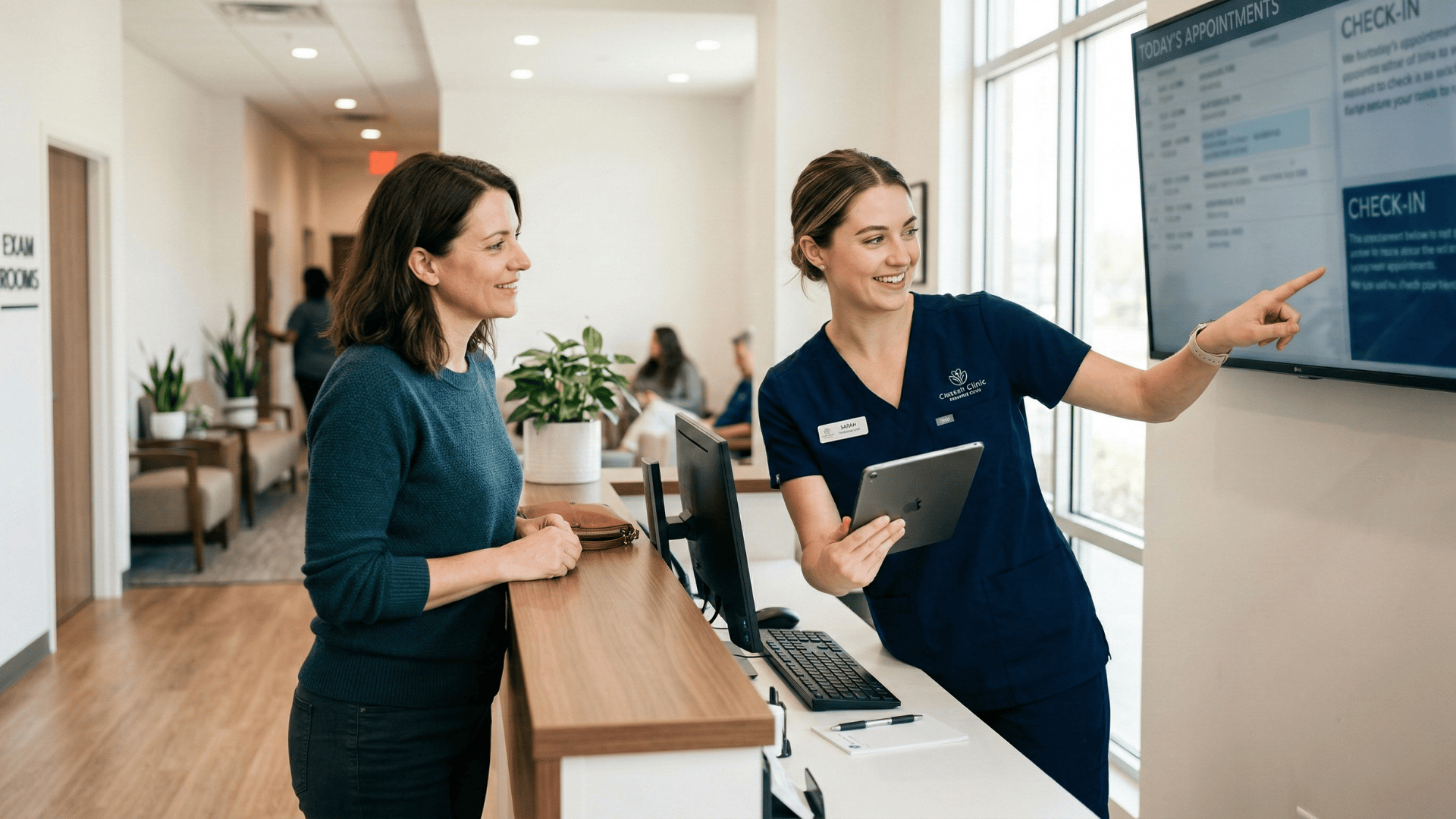 Front desk staff assisting a patient at a medical office reception counter