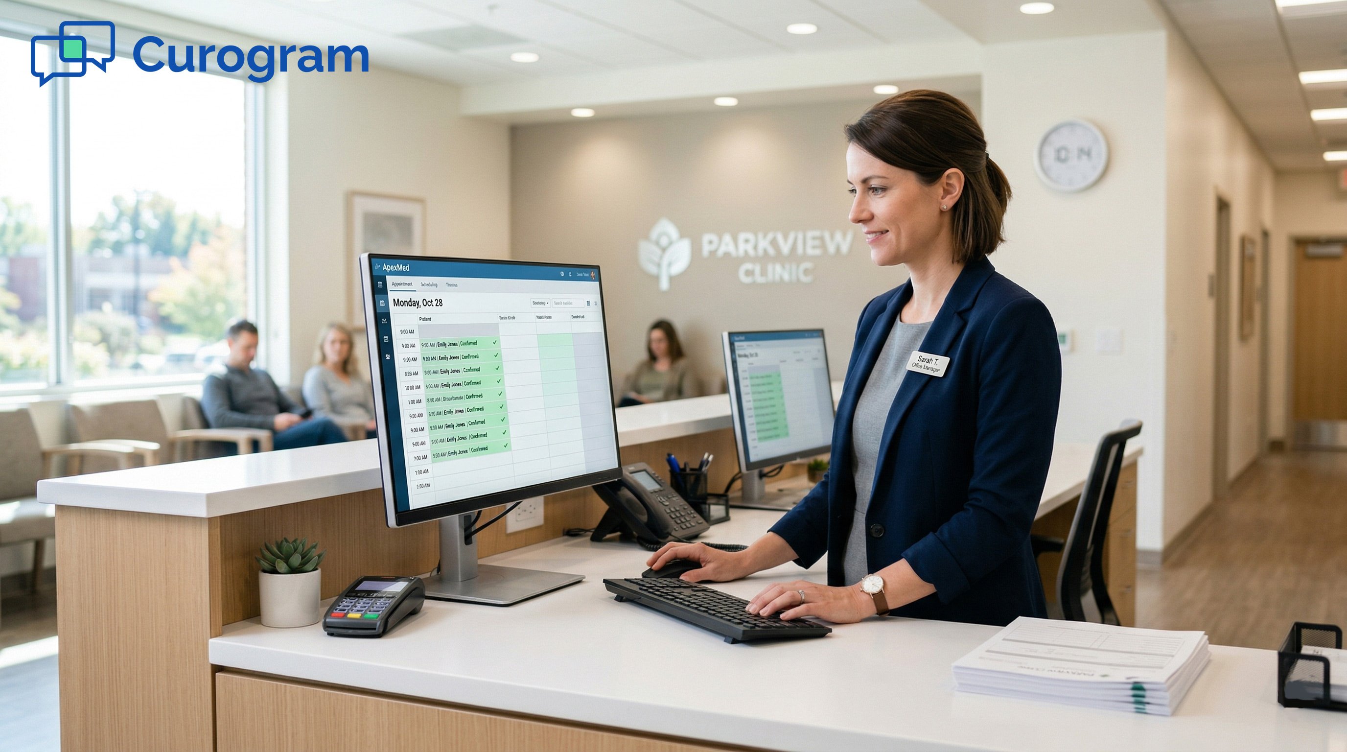 Smiling medical office receptionist at desk typing on computer