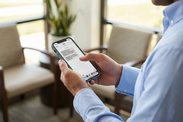 Close-up of a man's hands holding a smartphone with a medical reminder text