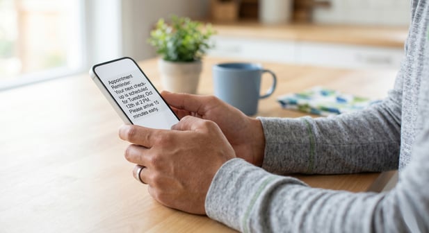 Close-up of hands holding a phone displaying a clear appointment reminder text