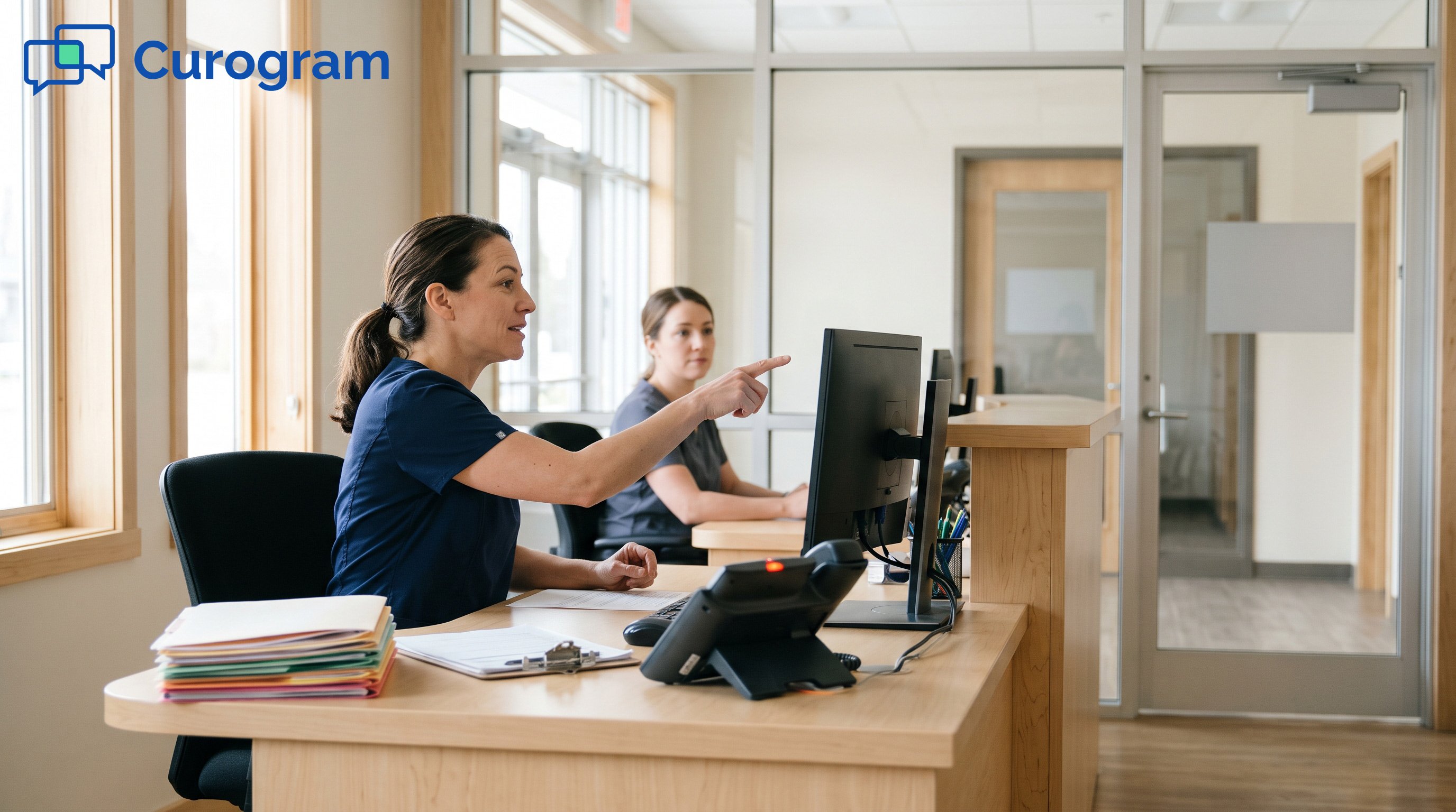 Two front desk staff at a small medical office coordinating patient messages between locations