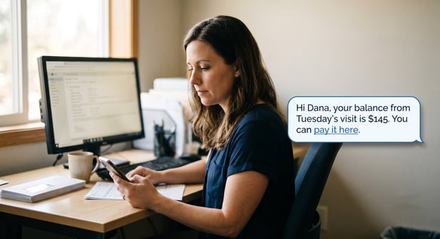 Candid photo of a clinic professional viewing a text bubble showing a patient's $145 balance