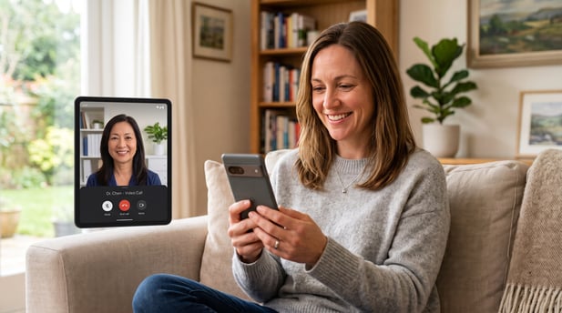 Smiling senior Asian woman at home holding a smartphone for a telehealth video call