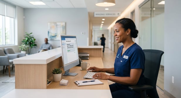 Smiling medical receptionist at a desk managing patient text communications