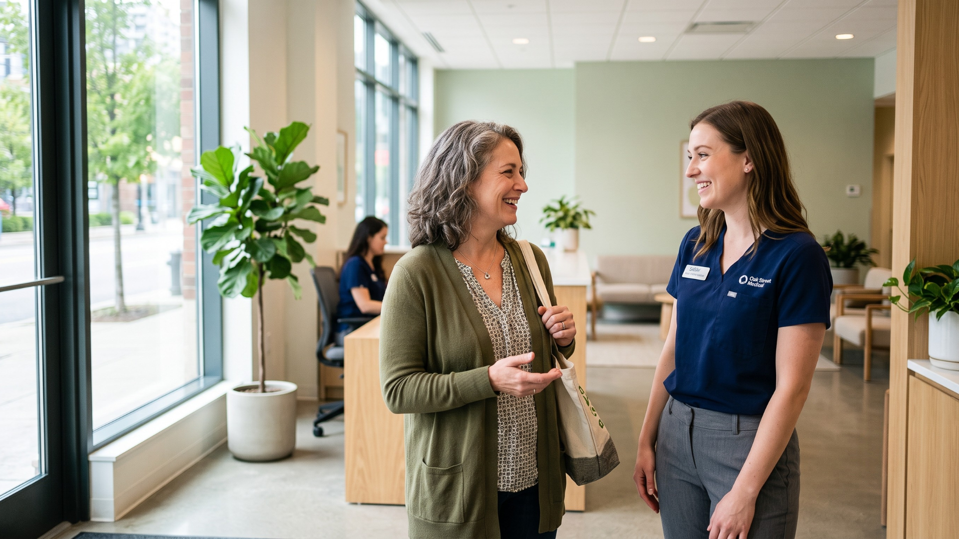 Returning patient warmly greeted by clinic staff at a bright medical office entrance