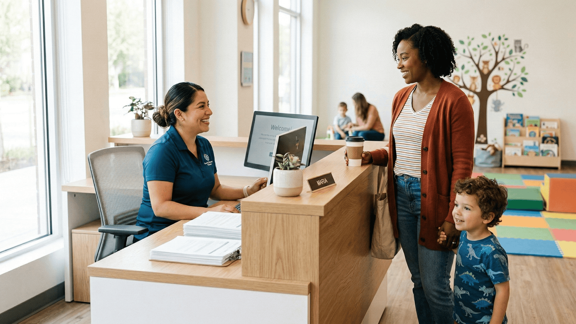 Front desk staff greeting a parent and child arriving for a pediatric therapy first appointment
