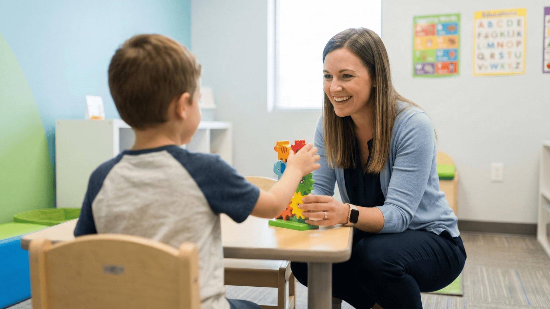 Occupational therapist engaging with a young child during a pediatric therapy session