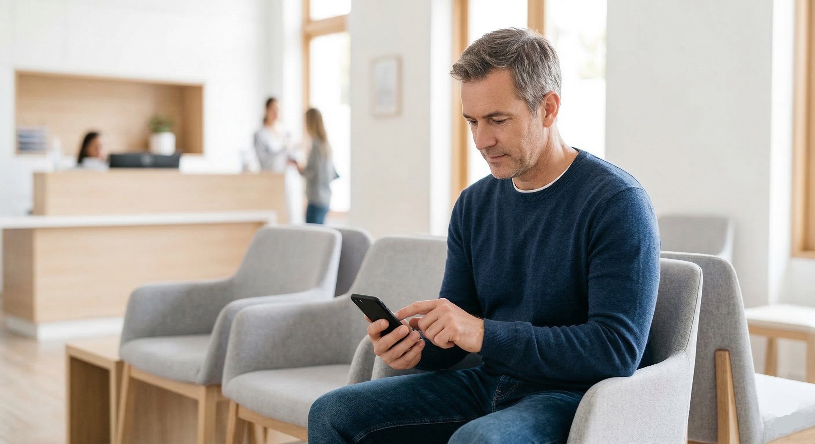 A patient completes a digital check-in form on their smartphone in a modern waiting room