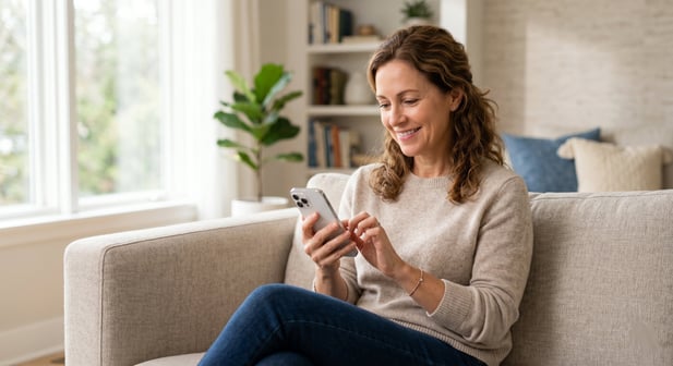 Patient seated at home completing digital medical intake on a smartphone